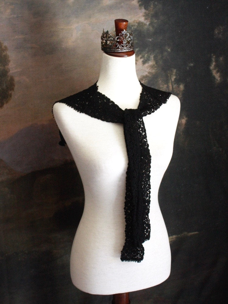 Historically Inspired Floral Crochet Folk Shawl / Capelet in Gothic Black on a mannequin in front of a painting backdrop. Victorian, renaissance, medieval.