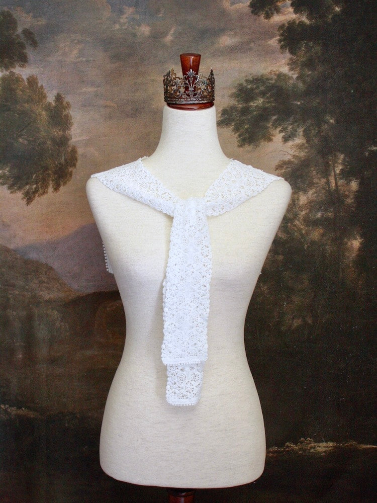 Historically Inspired Floral Crochet Folk Shawl / Capelet in White on a mannequin in front of a painting backdrop. Victorian, renaissance, medieval.
