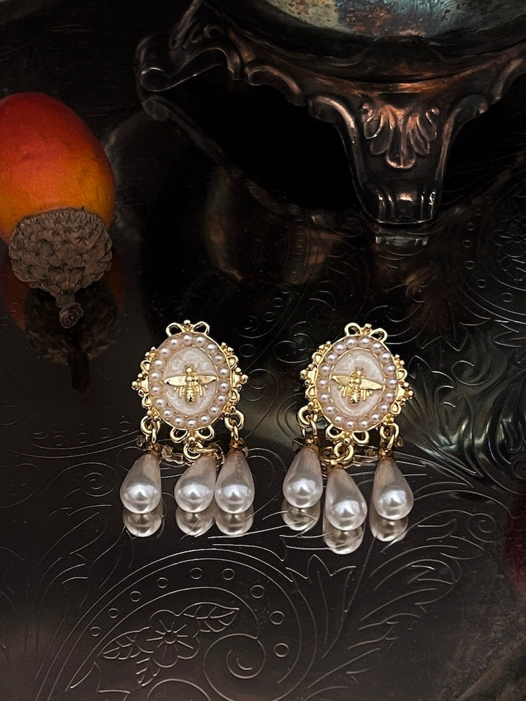 Historically inspired regency earrings with bee cameo, in white and gold, daphne bridgerton accessories on an antique dish.