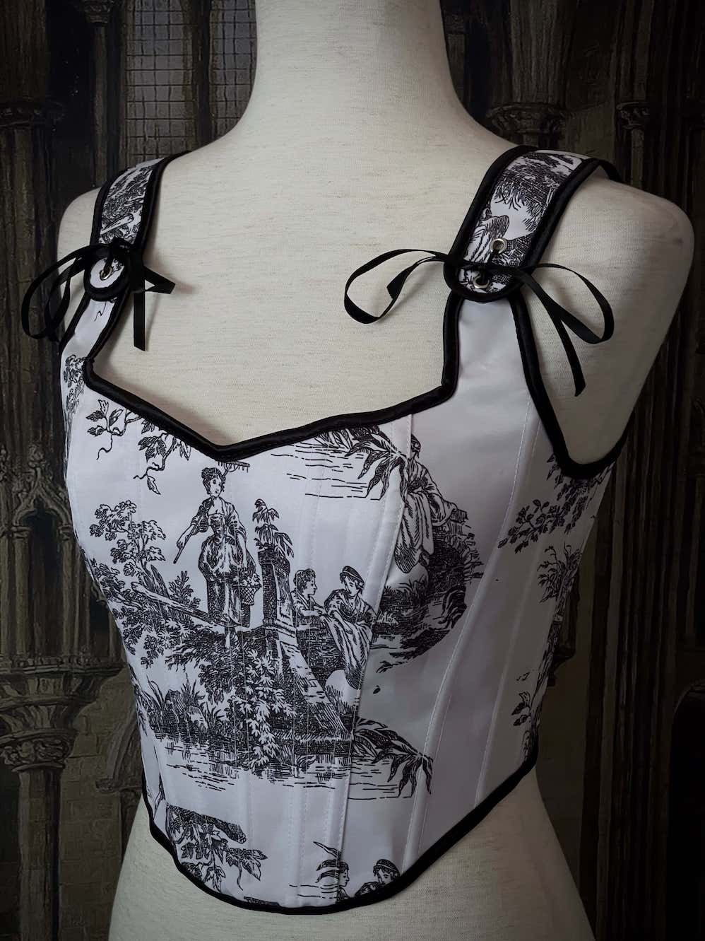 A Pair of Baroque & Rococo Era Gothic Black & White Toile Corset Stays with Satin Bowtied Ribbons.
