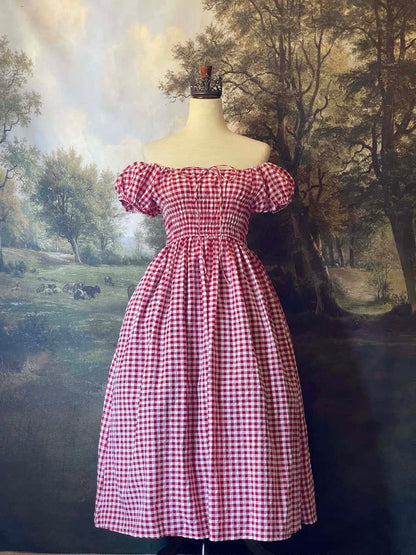 A historically inspired cottage vintage style bardot off shoulder milkmaid red gingham maxi dress with shirred bodice and puff sleeves.