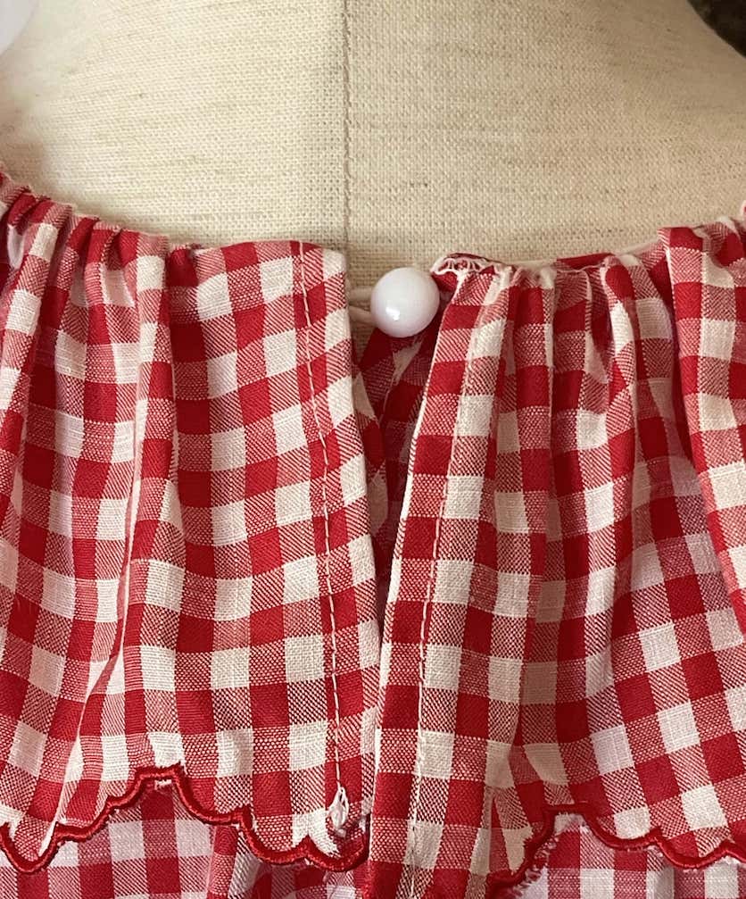 A Historically Inspired vintage style victorian countryside cottage gingham tunic dress in red and white, with ruffle collar and scalloped hem bishop sleeves.