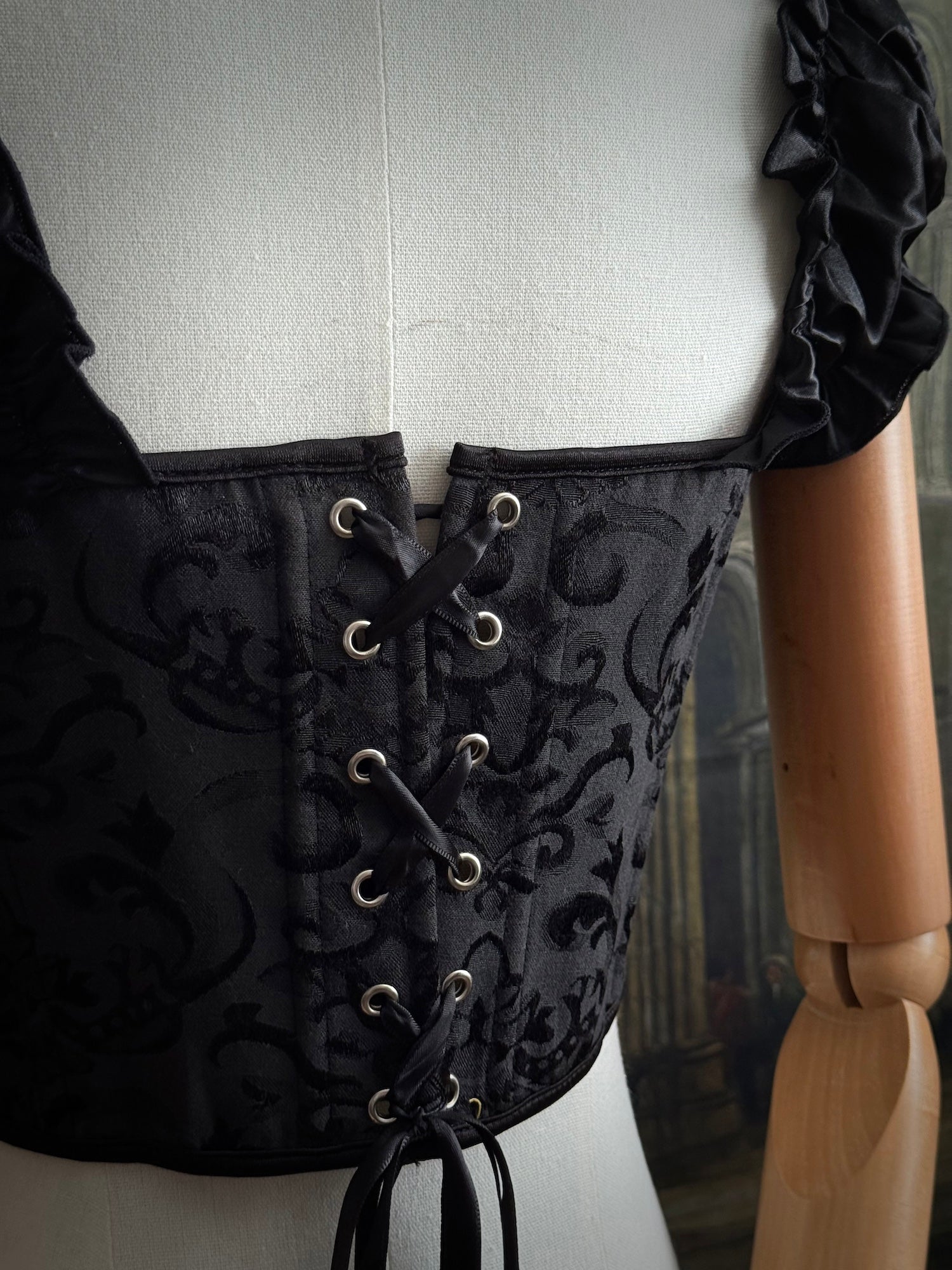 Corset lacing detail on a gothic black jacquard puff sleeve corset