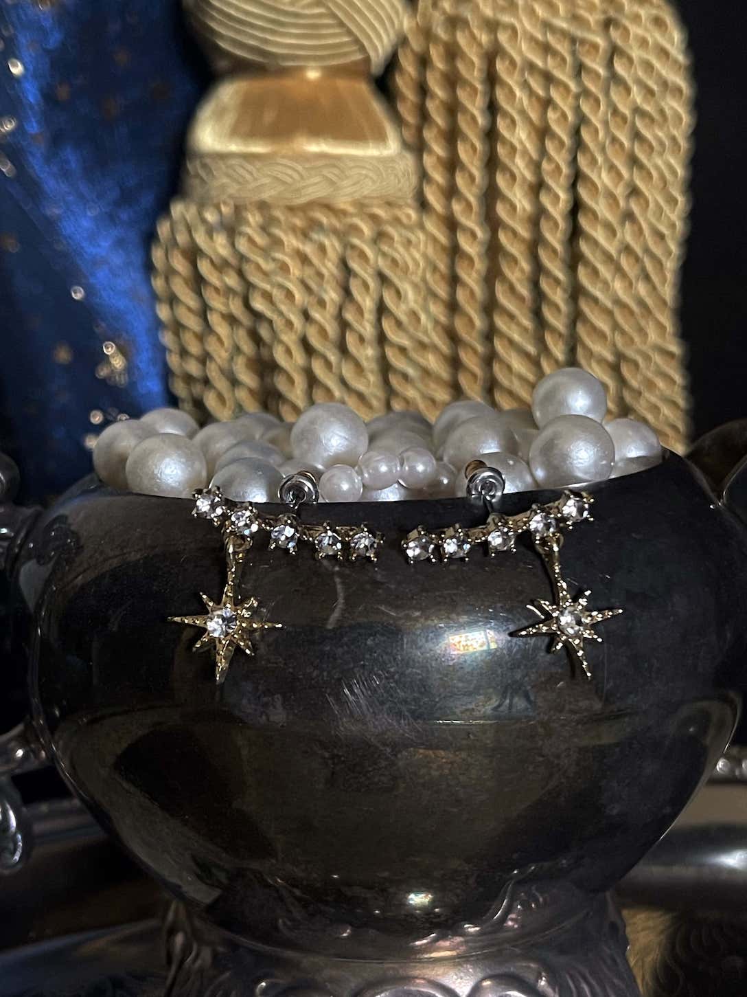 A pair of historically inspired fantasy astrology constellation star earrings in gold pictured in a whimsigoth celestial set.
