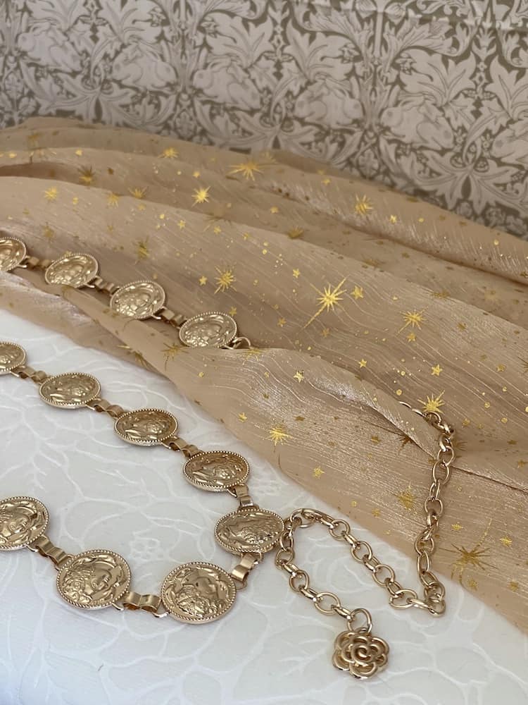 A Historically Inspired Renaissance and Medieval Classical Cameo Coin Belt in Gold on a celestial backdrop.