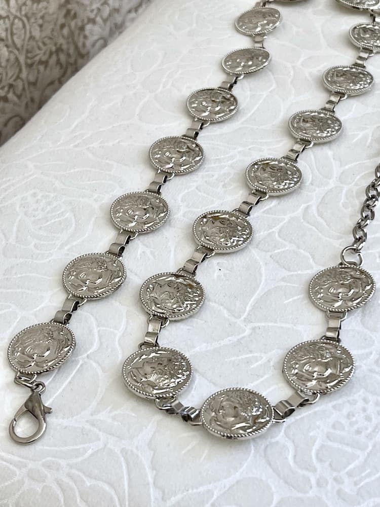 A Historically Inspired Renaissance and Medieval Classical Cameo Coin Belt in Silver pictured on a puff.