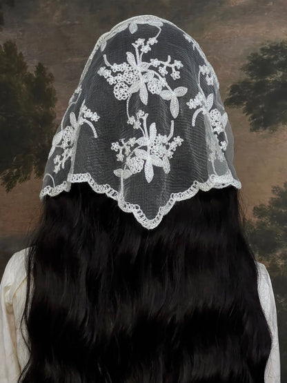 Mannequin wearing a vintage style ivory lace headscarf babushka triangle headdress made from floral embroidery lace against an art history background