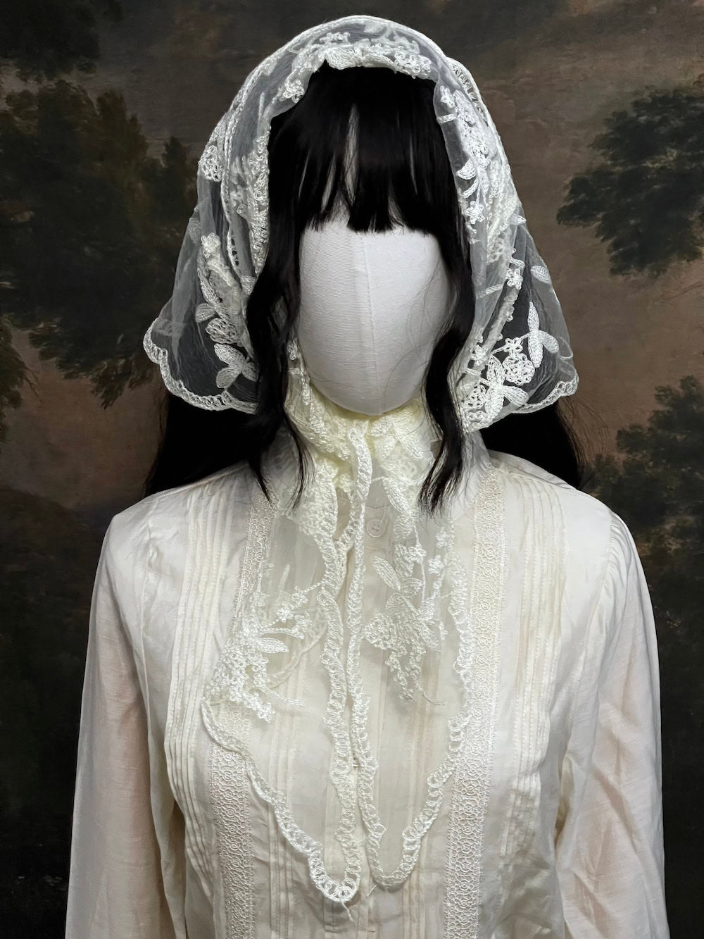 Mannequin wearing a vintage style ivory lace headscarf babushka triangle headdress made from floral embroidery lace against an art history background