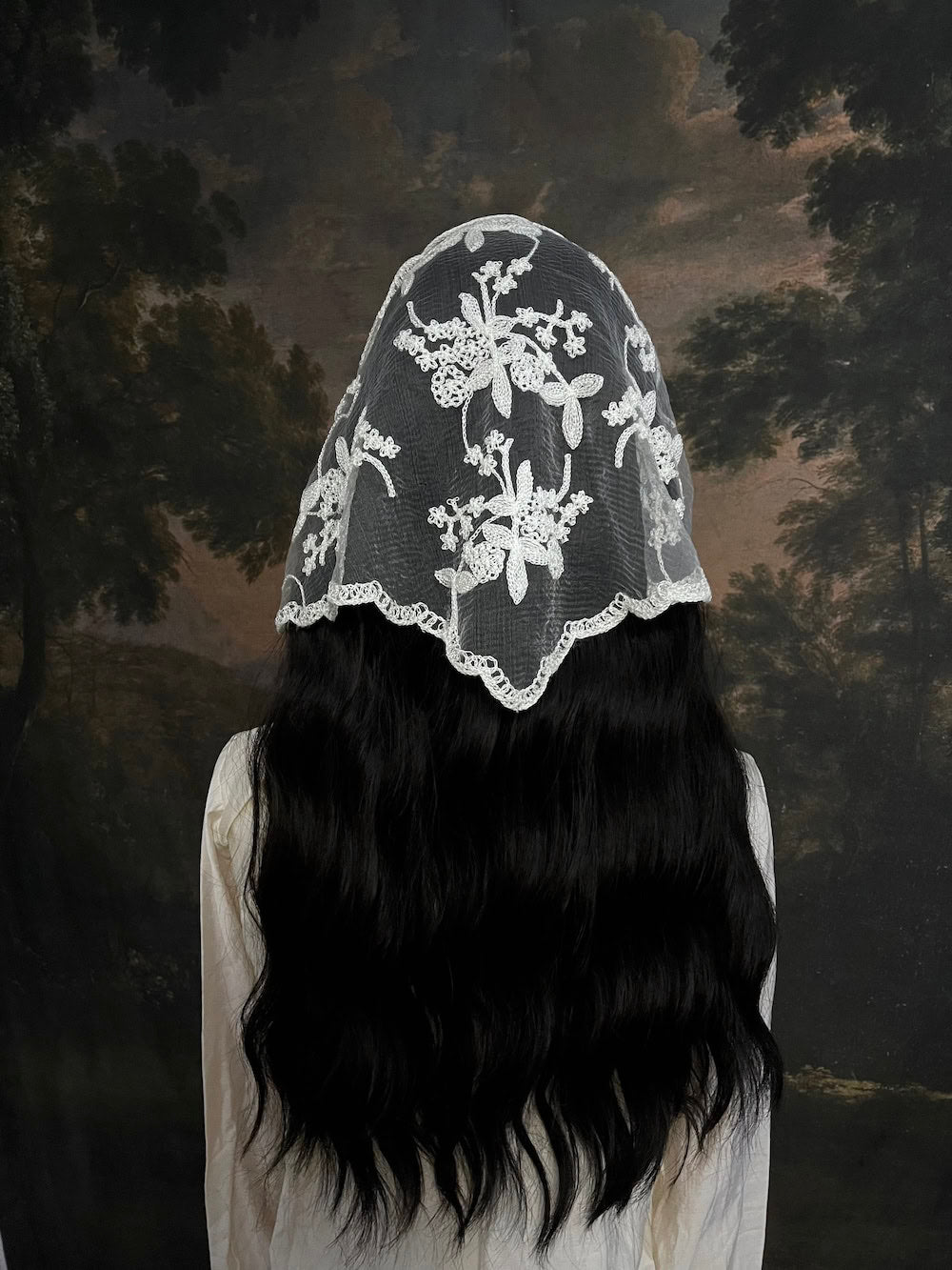 Mannequin wearing a vintage style ivory lace headscarf babushka triangle headdress made from floral embroidery lace against an art history background