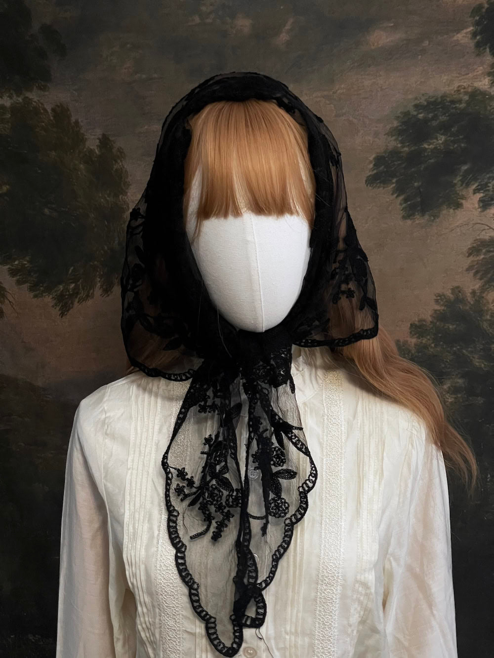 Mannequin wearing a vintage style gothic black lace headscarf babushka triangle headdress made from floral embroidery lace against an art history background