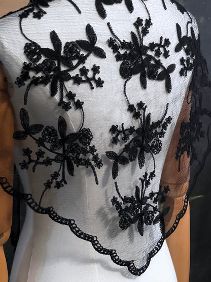 Mannequin wearing a vintage style gothic black lace headscarf babushka triangle headdress made from floral embroidery lace worn as a shawl against an art history background