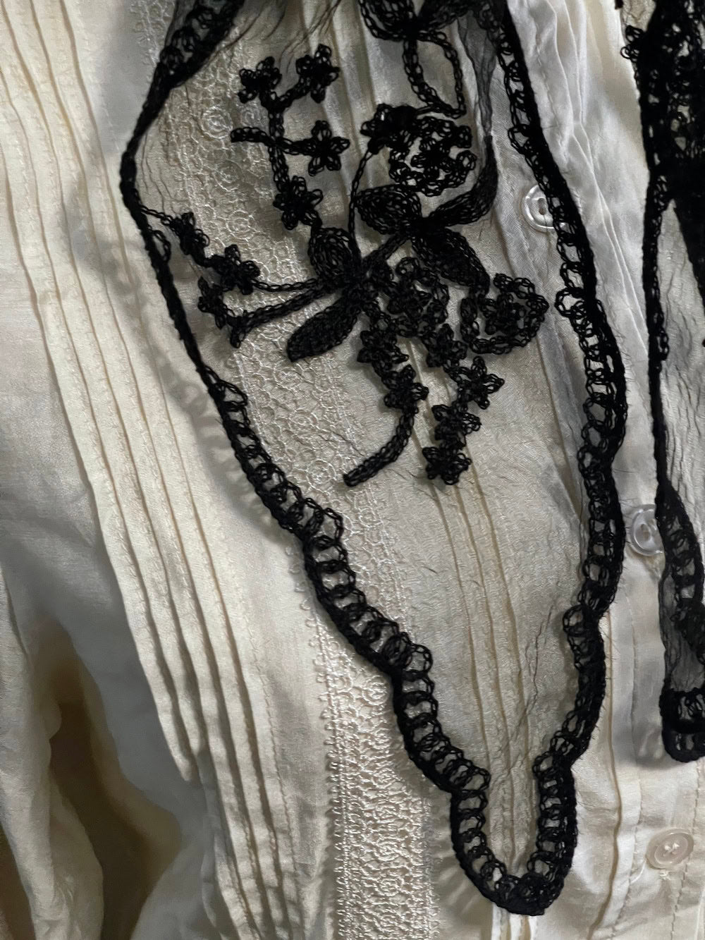 Detail of a vintage style gothic black lace headscarf babushka triangle headdress made from floral embroidery lace against an art history background