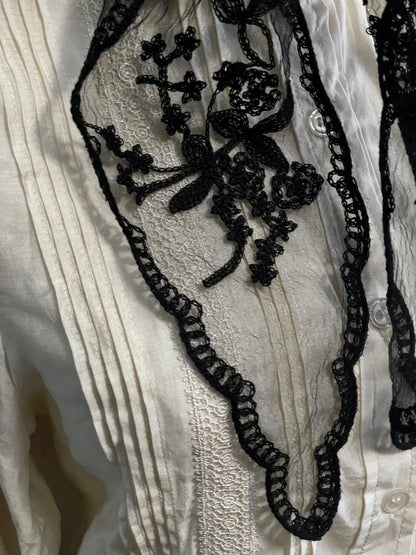 Detail of a vintage style gothic black lace headscarf babushka triangle headdress made from floral embroidery lace against an art history background