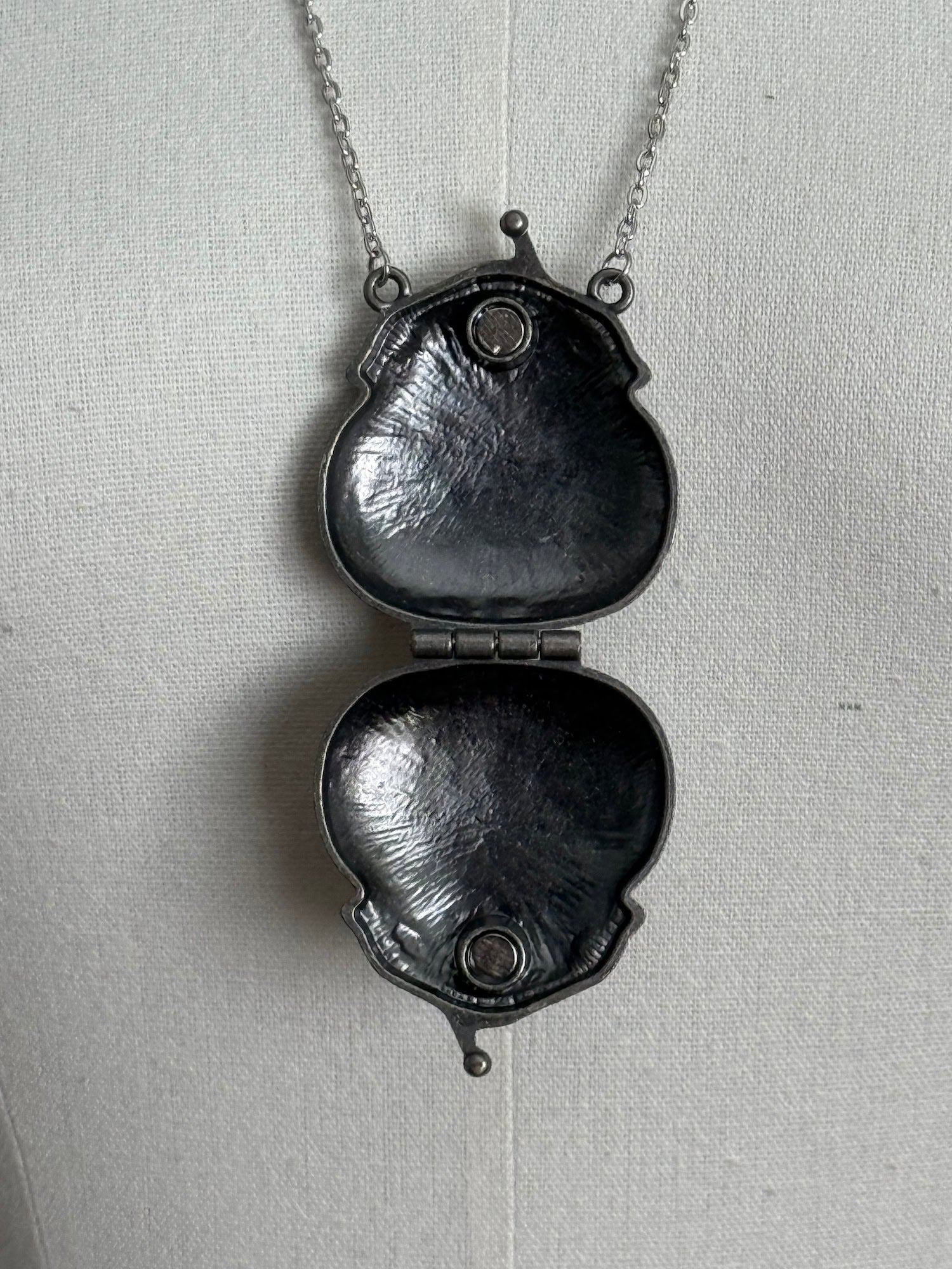 Victorian inspired historical coin purse trinket box pendant necklace with repousse designs in a darkened tarnished finish. Inside view