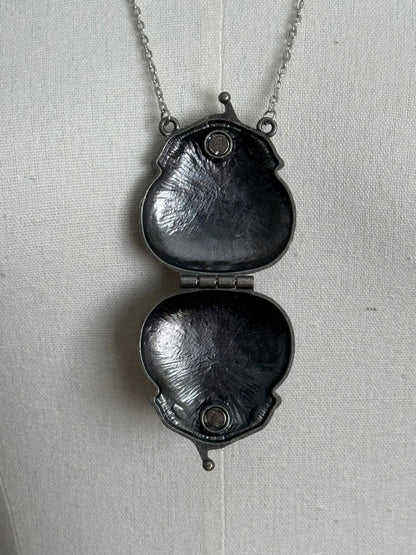 Victorian inspired historical coin purse trinket box pendant necklace with repousse designs in a darkened tarnished finish. Inside view