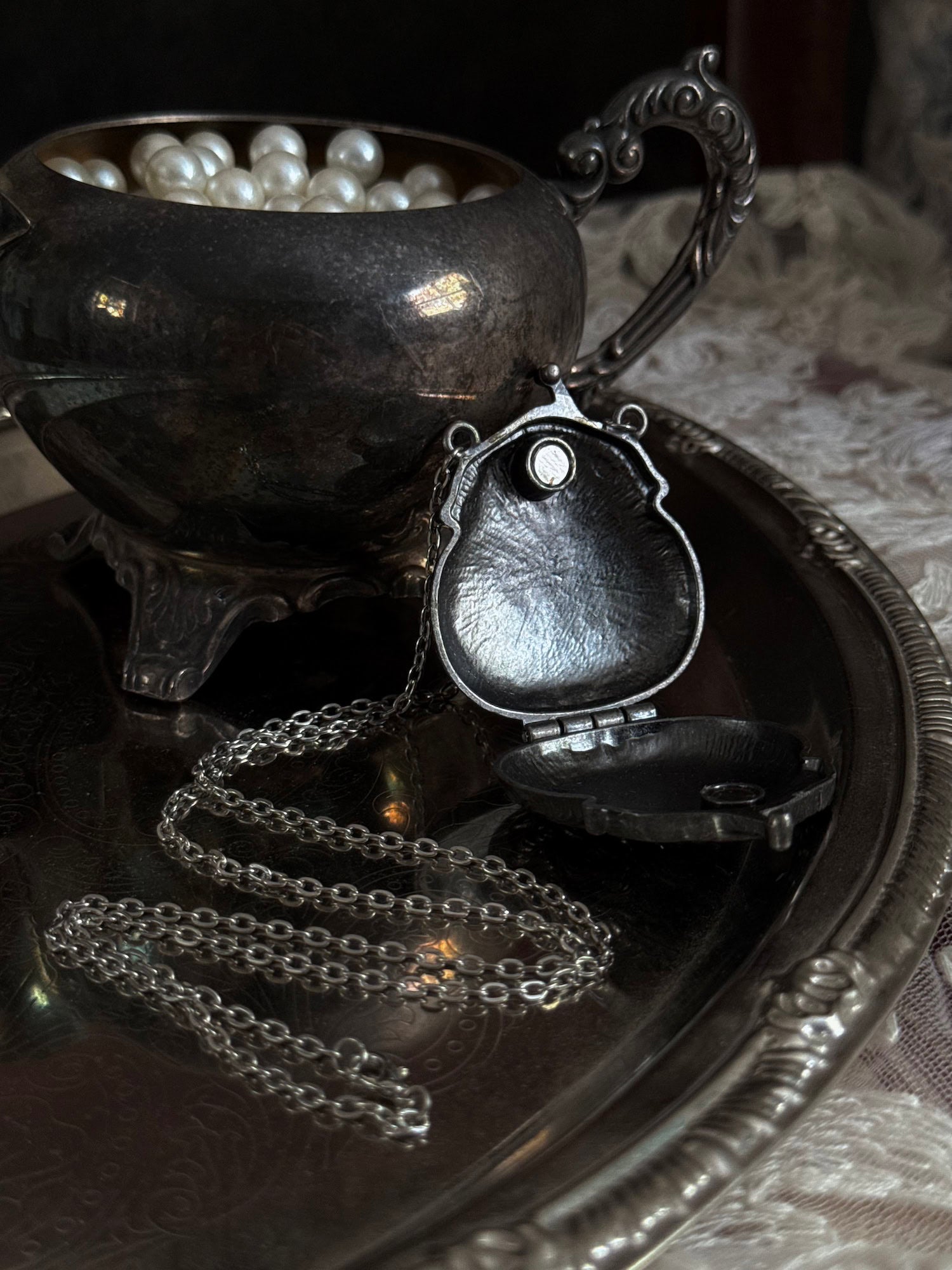 Victorian inspired historical coin purse trinket box pendant necklace with repousse designs in a darkened tarnished finish. Inside view.