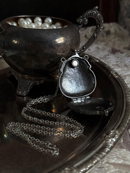 Victorian inspired historical coin purse trinket box pendant necklace with repousse designs in a darkened tarnished finish. Inside view.