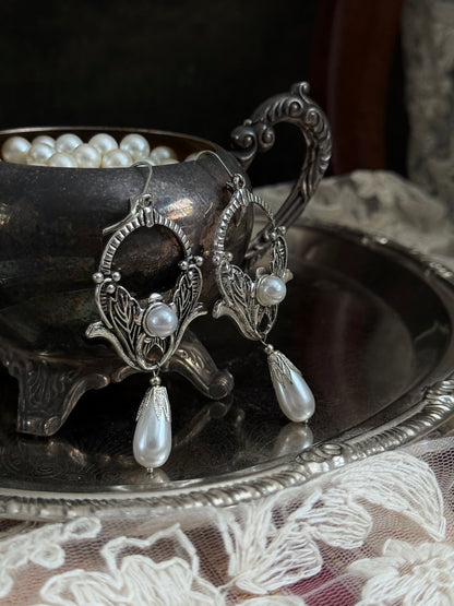 Historically inspired Turn-of-the-Century Art Nouveau Silverwork style  Earrings with Pearl Dangle displayed on an antique silver dish