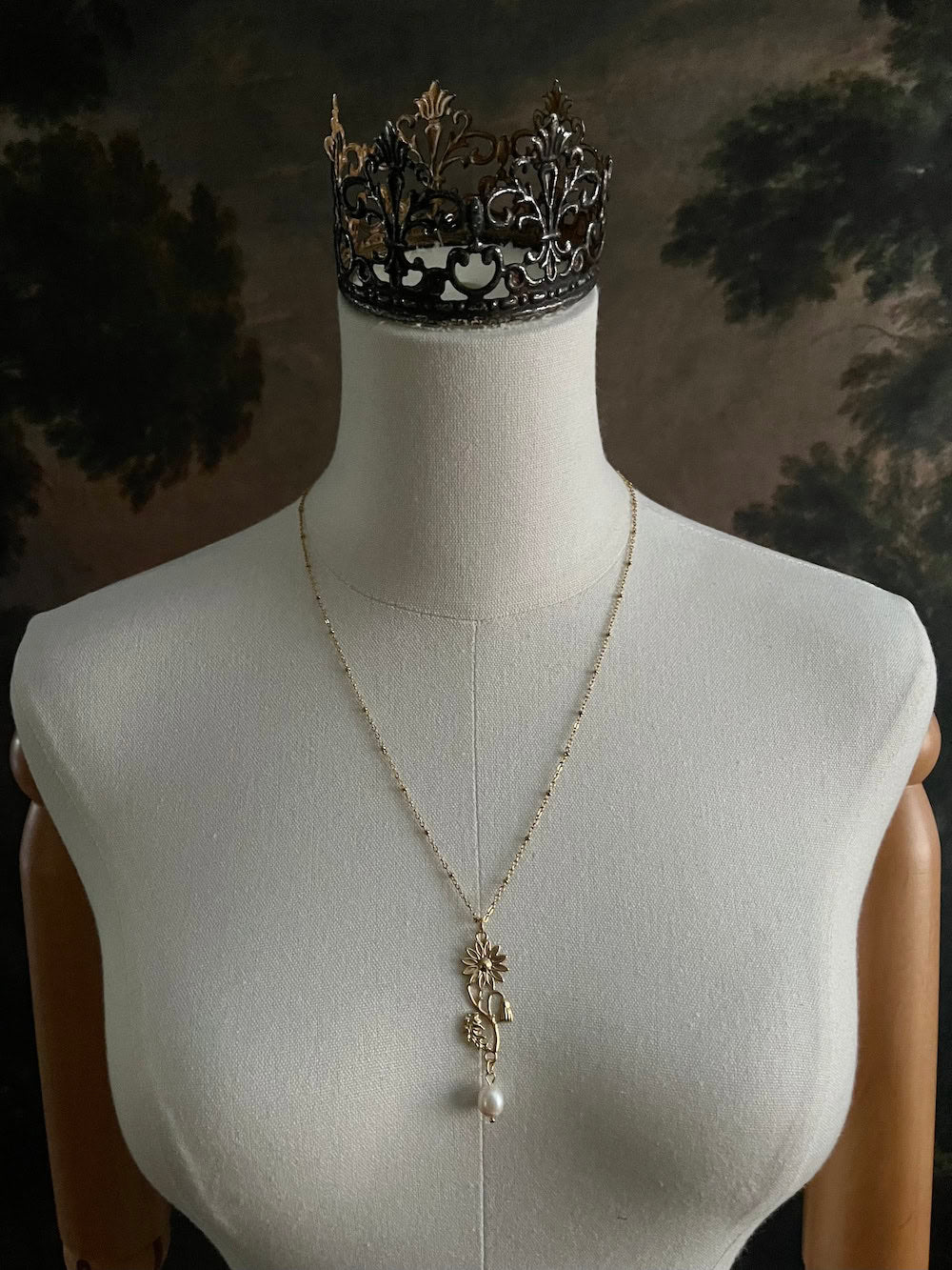 A historical jewelry inspired vintage style daisy flower pendant necklace with pearl dangle in gold toned stainless steel