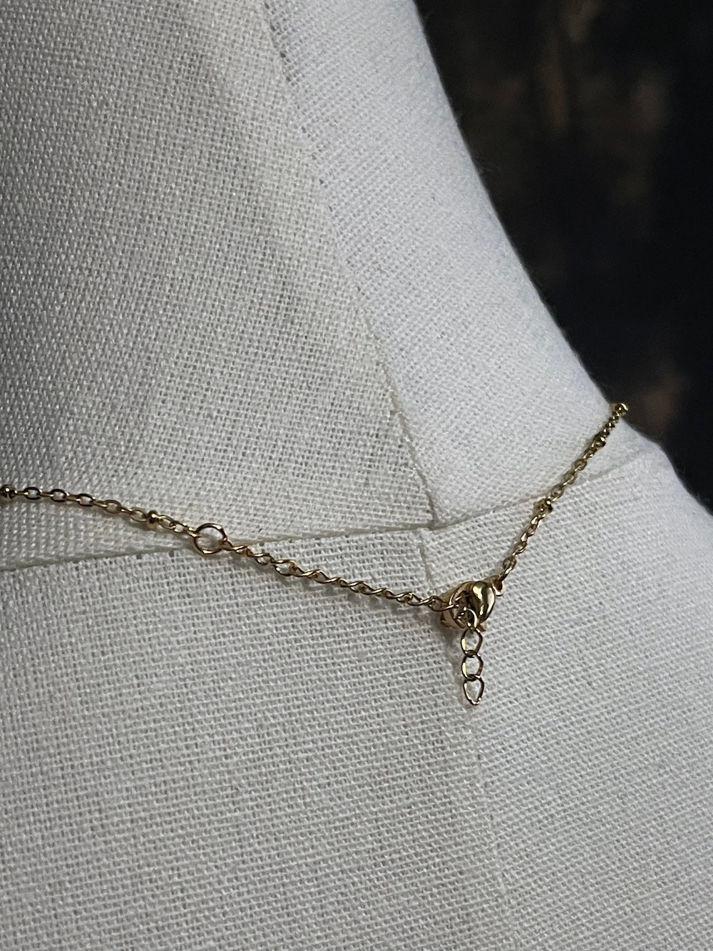 A historical jewelry inspired vintage style daisy flower pendant necklace with pearl dangle in gold toned stainless steel