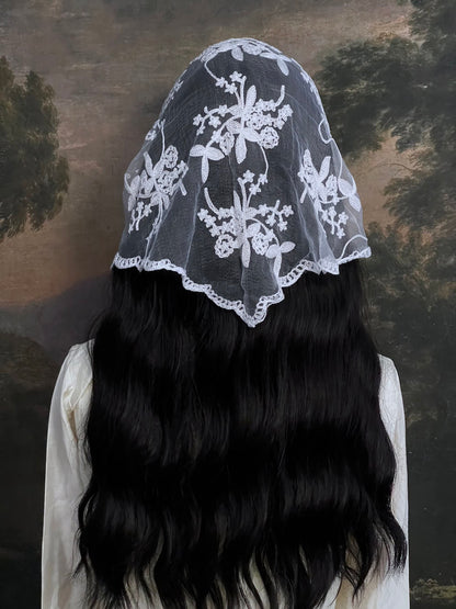 Mannequin wearing a vintage style white lace headscarf babushka triangle headdress made from floral embroidery lace against an art history background
