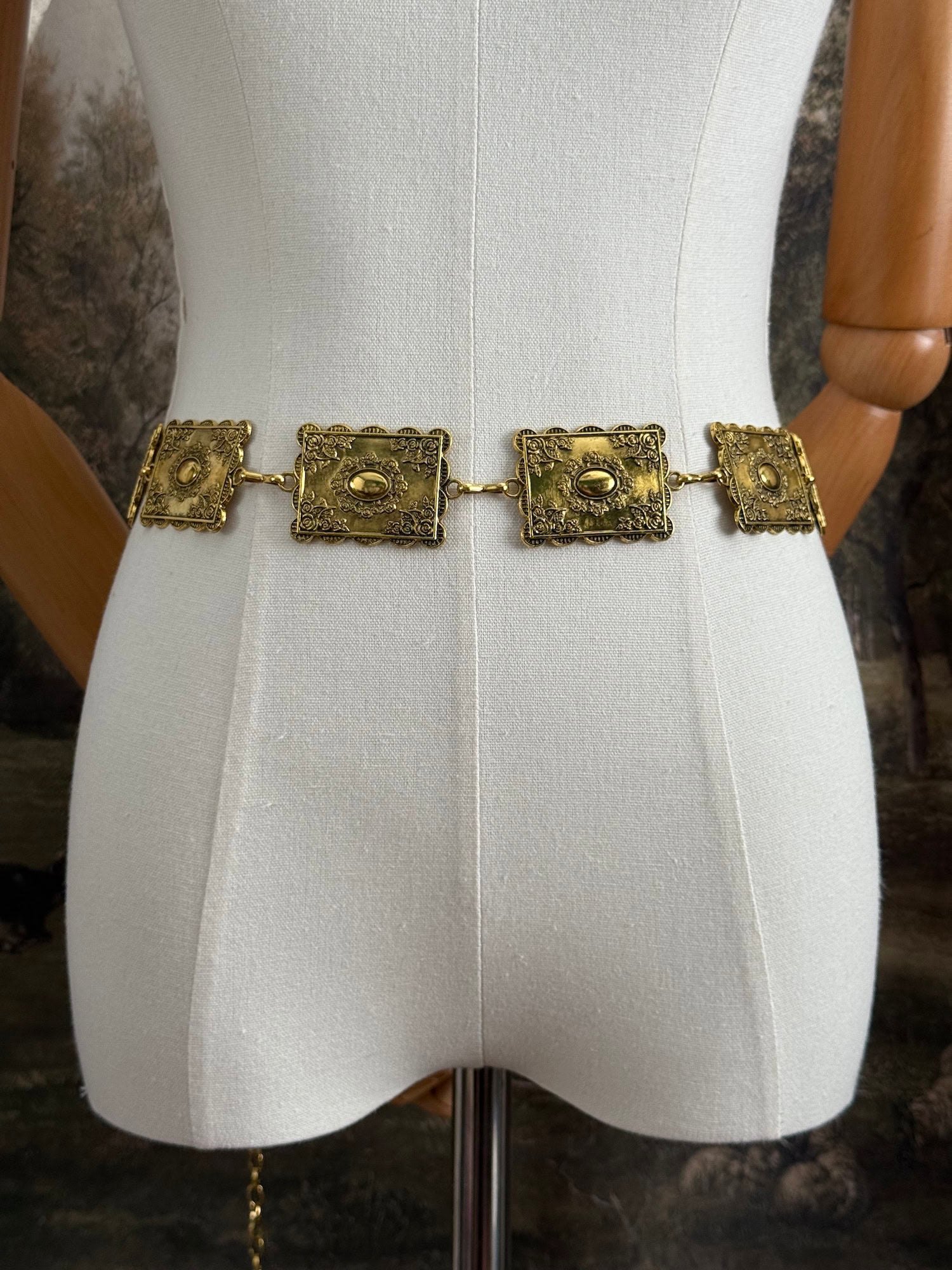 Historically inspired victorian era square concho style belt with rectangular gold toned metalwork, a scalloped edge, and floral motifs.