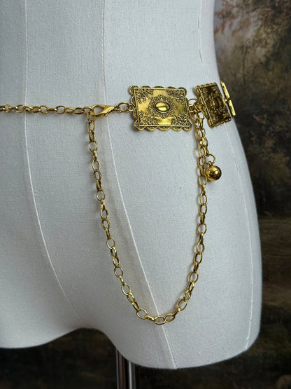 Historically inspired victorian era square concho style belt with rectangular gold toned metalwork, a scalloped edge, and floral motifs.