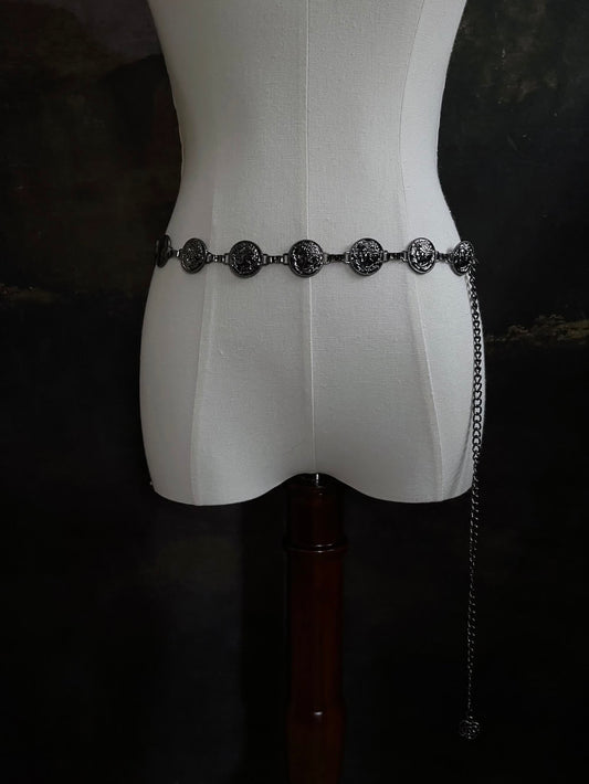 A historically inspired renaissance and medieval metal cameo coin belt in dark charcoal metal on a mannequin.