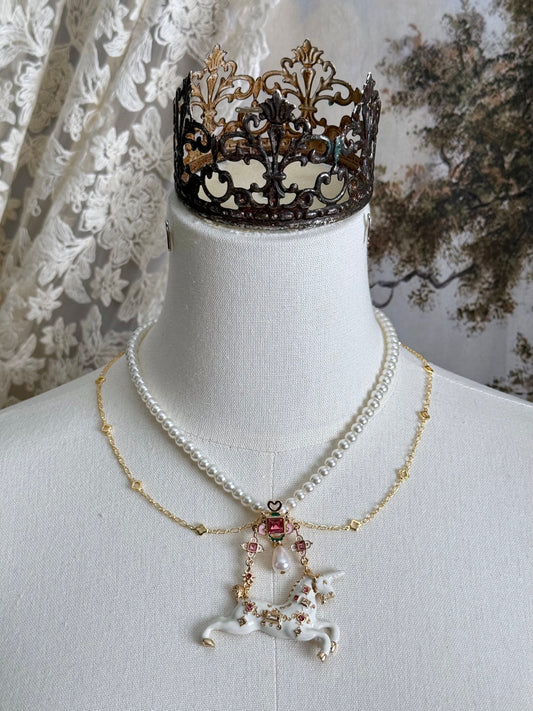 Handmade historical jewelry inspired pearl and chain necklace with a bejeweled medieval unicorn pendant, displayed on a mannequin.