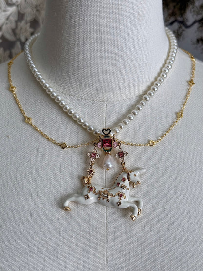 Handmade historical jewelry inspired pearl and chain necklace with a bejeweled medieval unicorn pendant, displayed on a mannequin.