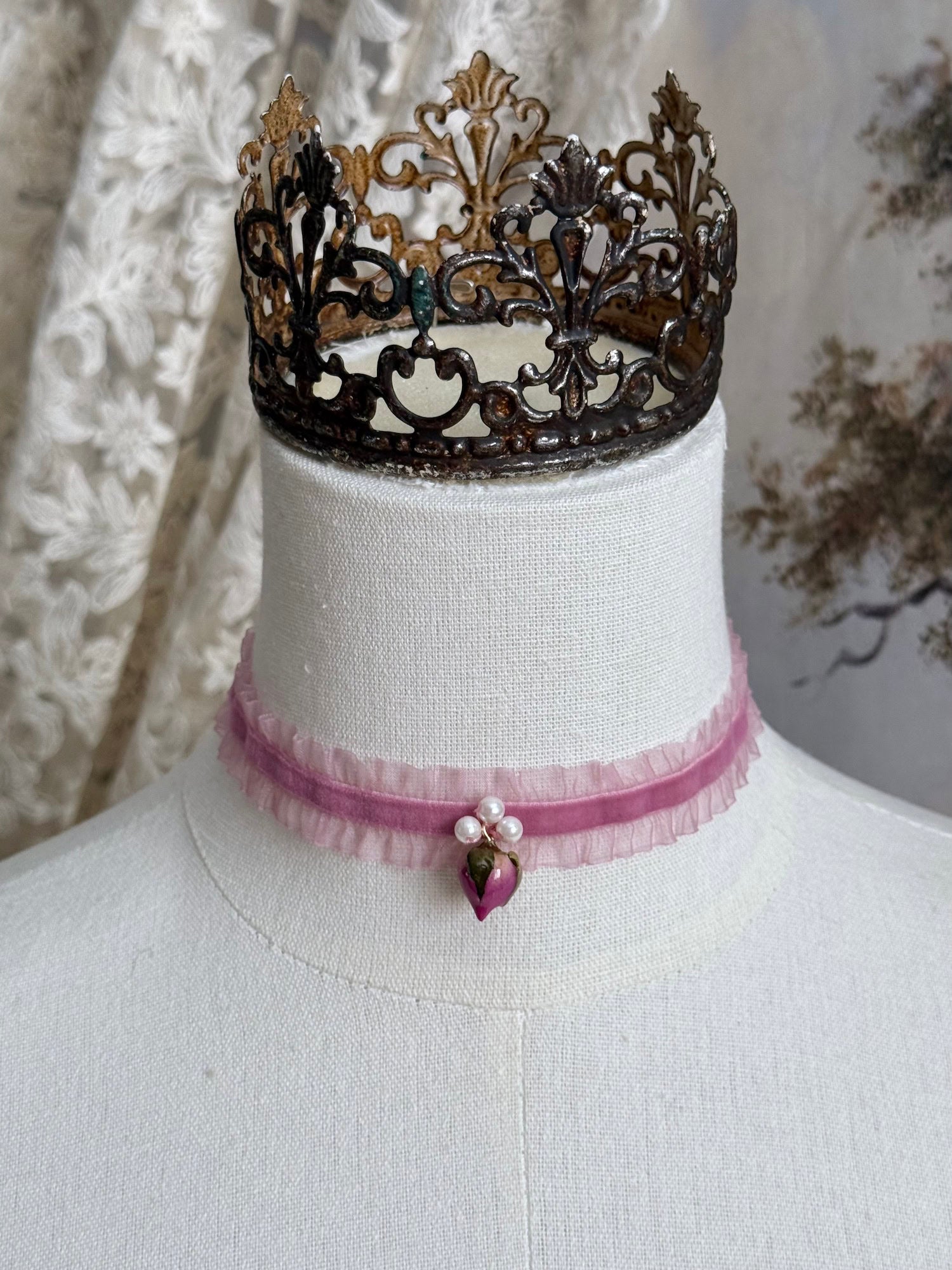 A victorian fashion inspired mauve pink velveteen and chiffon ruffle lace choker necklace with a real rose bud charm and three faux pearl beads pictured on a mannequin