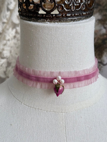 A victorian fashion inspired mauve pink velveteen and chiffon ruffle lace choker necklace with a real rose bud charm and three faux pearl beads pictured on a mannequin