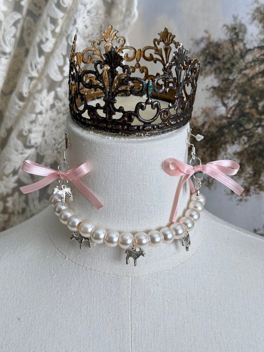 A vintage inspired handmade set of jewelry (earrings and necklace) featuring faux pearl beads, silver lamb charms,  and pastel pink ribbon bows.