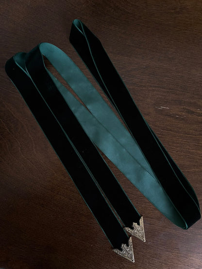 Dark Forest Green medieval style Velvet Belt with gold toned antique belt tips on a wooden table