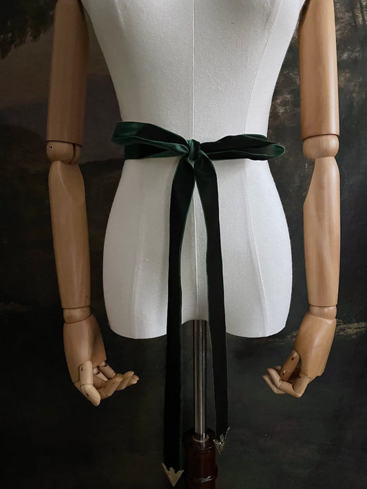 Dark Forest Green medieval style Velvet Belt with gold toned antique belt tips tied in a bow in front of an art history backdrop