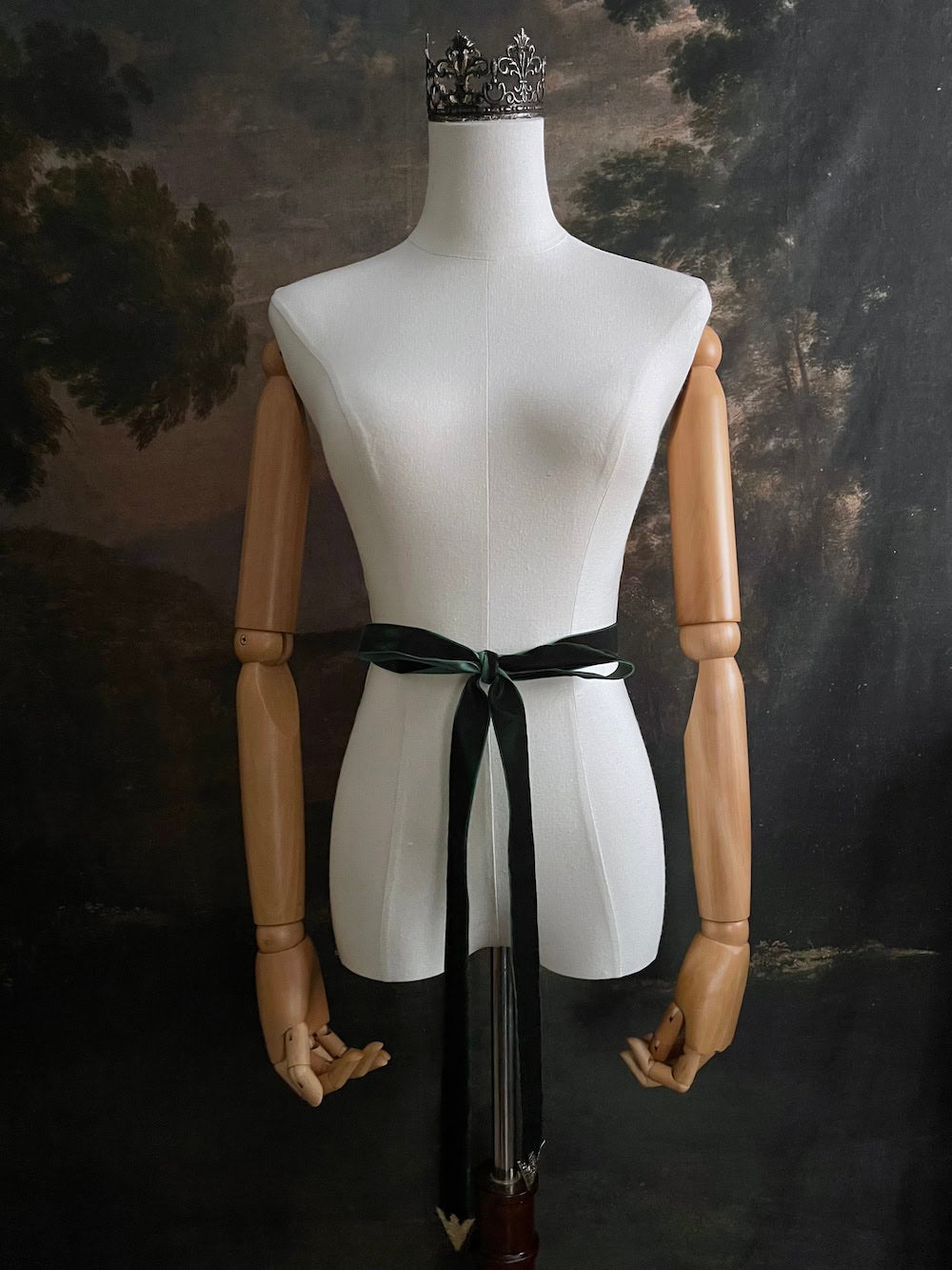 Dark Forest Green medieval style Velvet Belt with gold toned antique belt tips tied in a bow in front of an art history backdrop