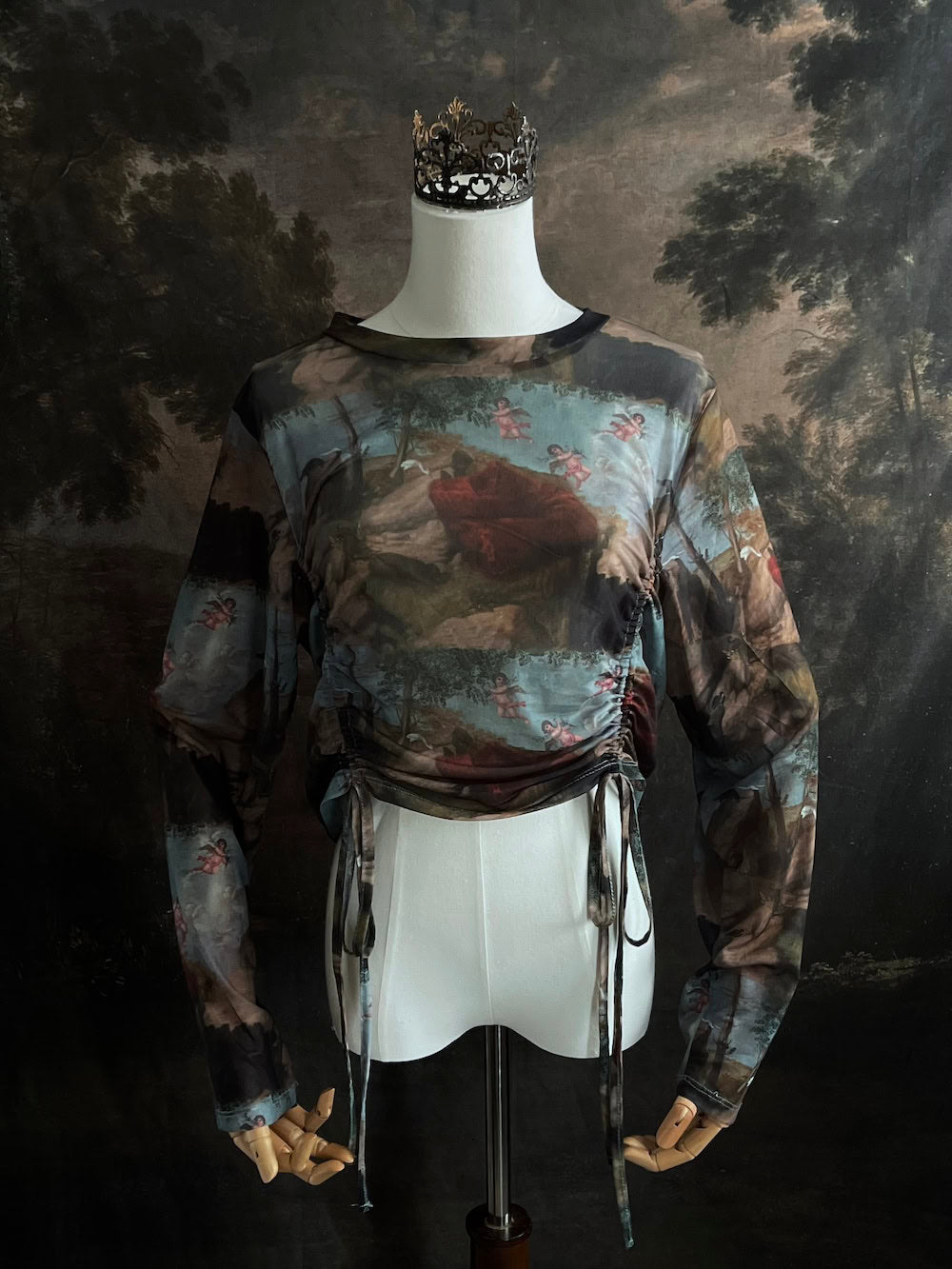 A Historical Renaissance Painting Printed Sheer Mesh Long-Sleeve Ruched Blouse on a mannequin in front of an art history backdrop