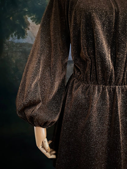 A medieval knight inspired metallic brown / bronze tunic dress with puffy bishop sleeves on a mannequin in front of an art history backdrop