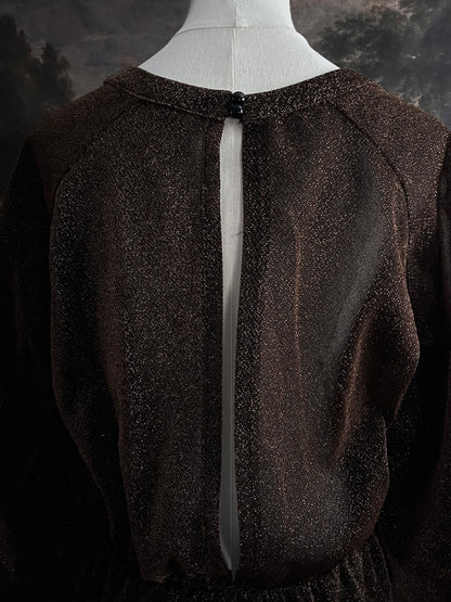 A medieval knight inspired metallic brown / bronze tunic dress with puffy bishop sleeves on a mannequin in front of an art history backdrop