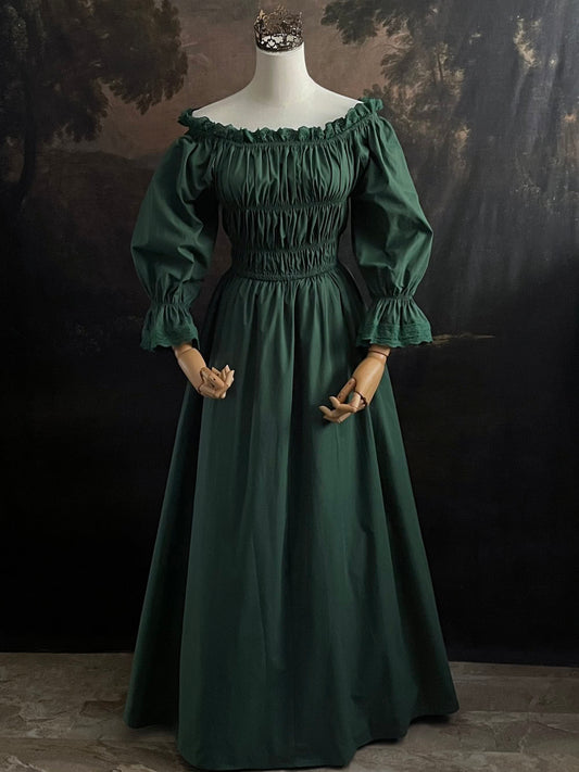 Dark Forest Green historical fashion inspired shirred chemise maxi dress gown with lace trim and bell sleeves on a mannequin against a dark forest background