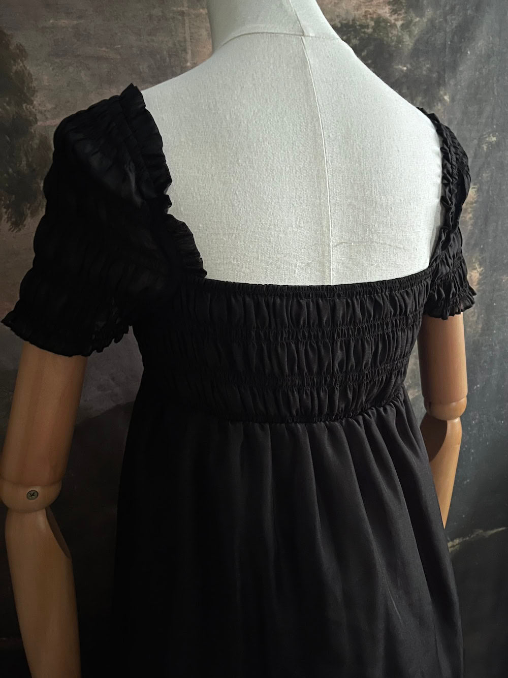 A historical fashion inspired regency era style black tiered empire waist mini dress with shirred square neckline bodice