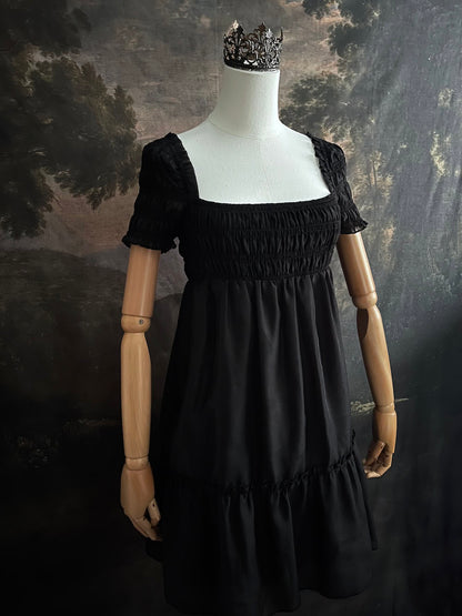 A historical fashion inspired regency era style black tiered empire waist mini dress with shirred square neckline bodice