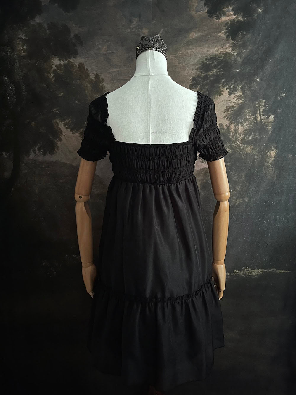 A historical fashion inspired regency era style black tiered empire waist mini dress with shirred square neckline bodice