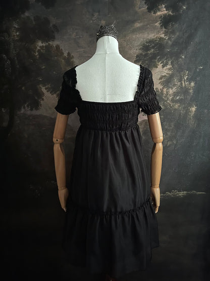 A historical fashion inspired regency era style black tiered empire waist mini dress with shirred square neckline bodice
