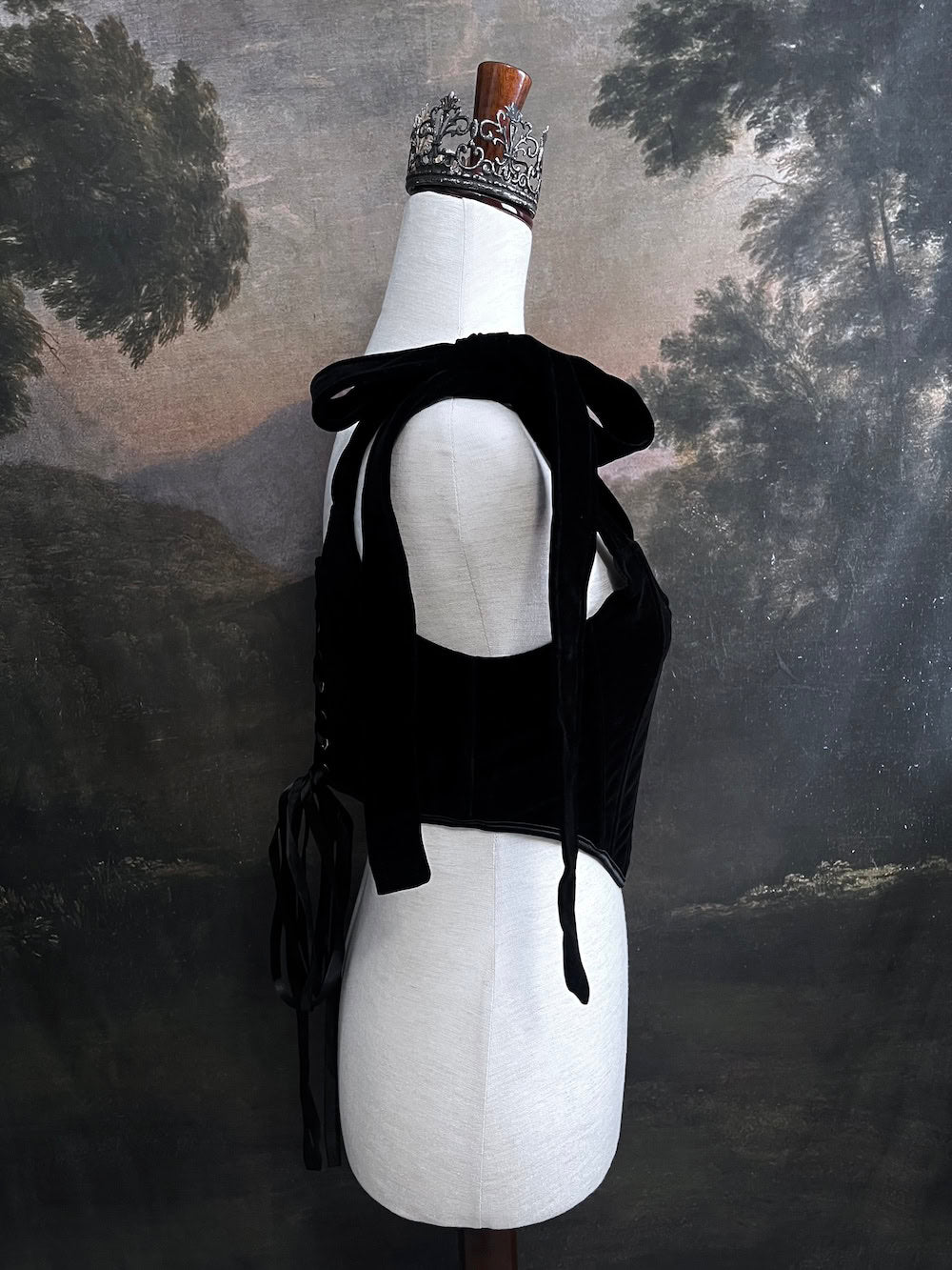 A pair of historical fashion inspired renaissance and baroque era gothic black velvet corset stays with bow straps, a basque waist, and a square neckline.