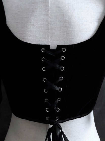 A pair of historical fashion inspired renaissance and baroque era gothic black velvet corset stays with bow straps, a basque waist, and a square neckline.