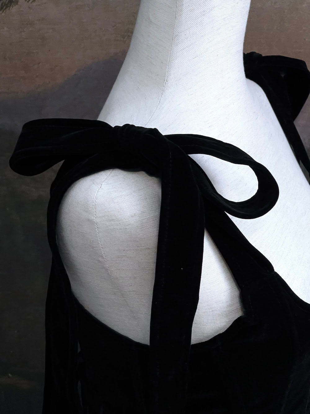 A pair of historical fashion inspired renaissance and baroque era gothic black velvet corset stays with bow straps, a basque waist, and a square neckline.