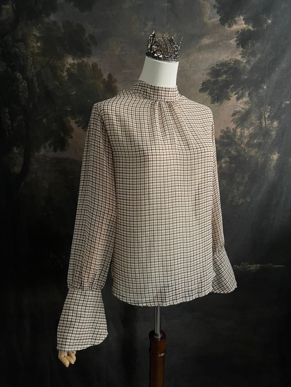 Mannequin wearing a vintage style historically inspired gingham check plaid blouse with bell sleeves and a mock neckline