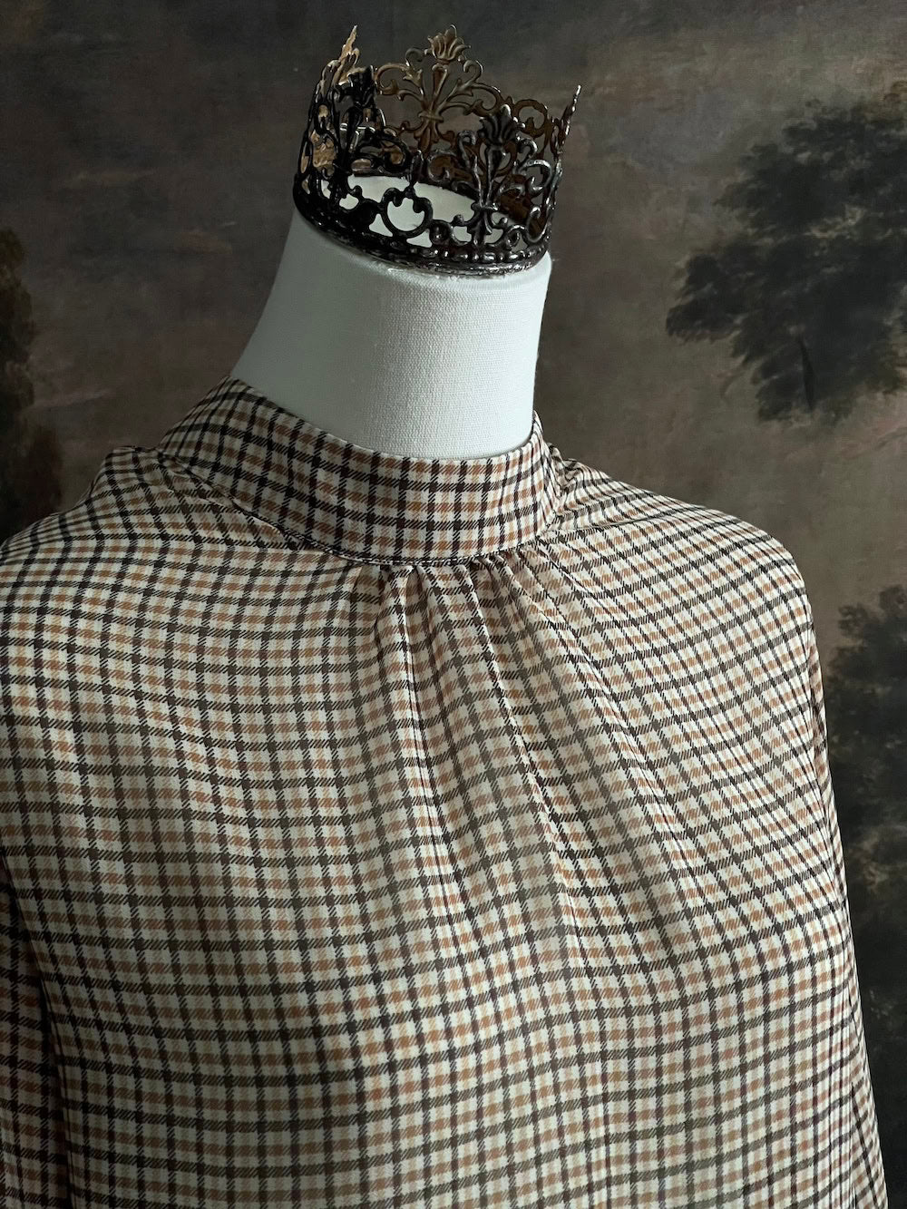 Mannequin wearing a vintage style historically inspired gingham check plaid blouse with bell sleeves and a mock neckline
