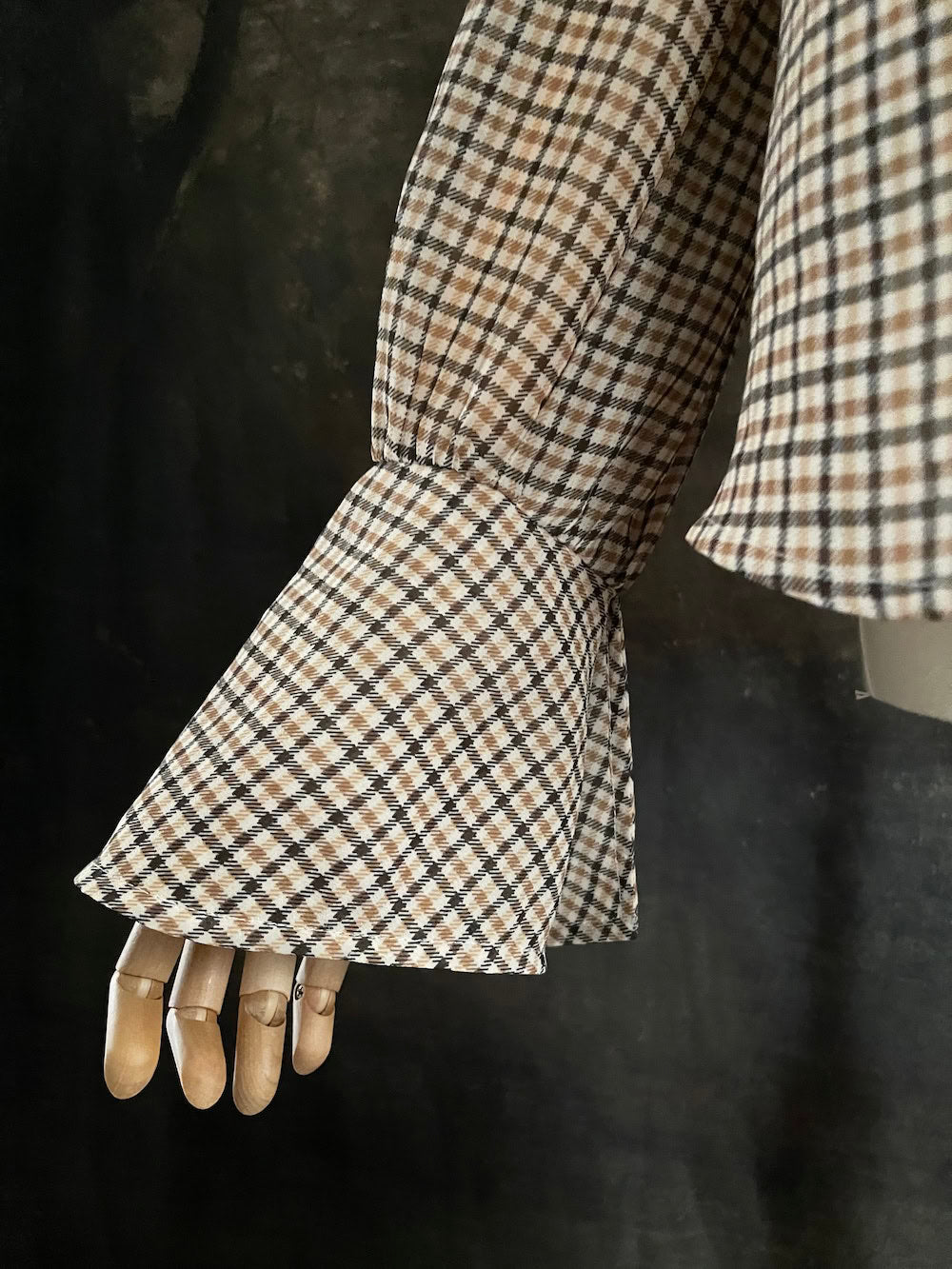Mannequin wearing a vintage style historically inspired gingham check plaid blouse with bell sleeves and a mock neckline